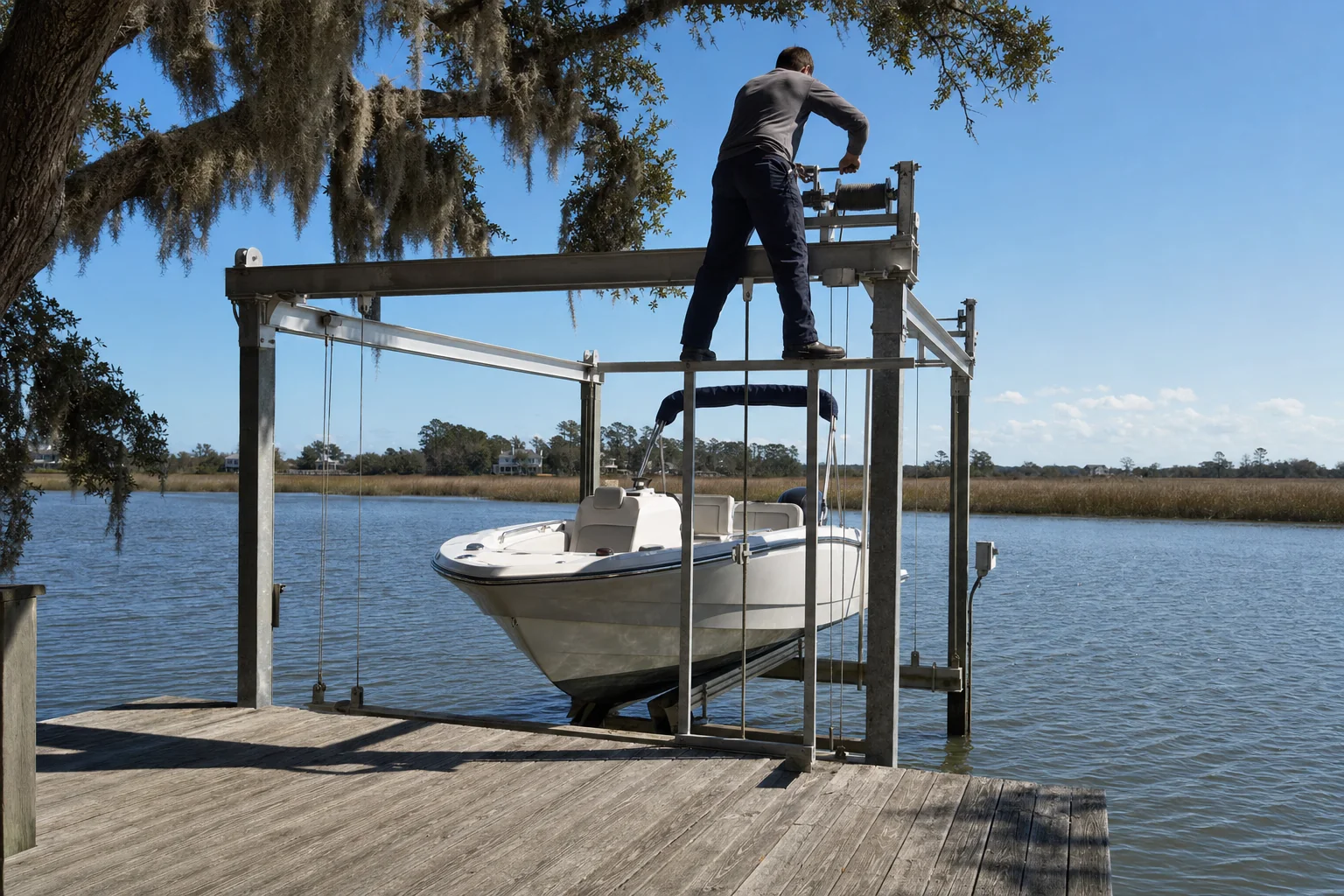 Technician inspects boat lift mechanism at Wilmington waterfront dock with moored vessel.